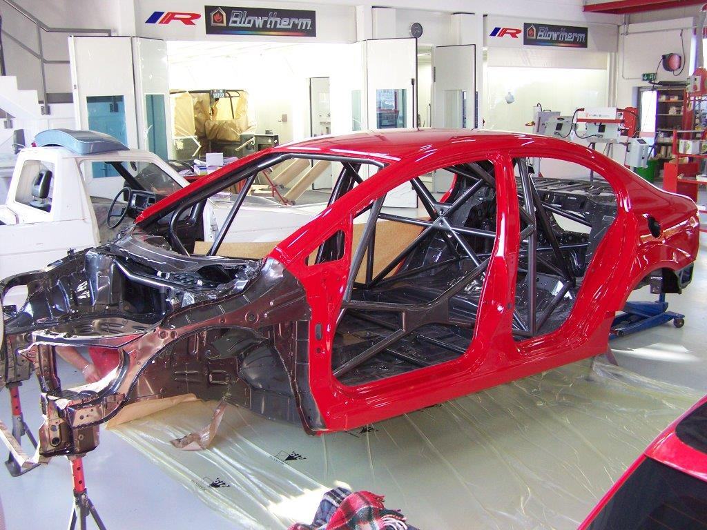 Caisse de voiture rouge mise à nu en atelier